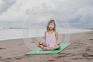 cute little child practicing yoga in lotus pose with gyan mudra
