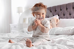 Cute little child sitting on bed