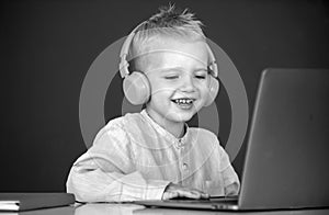 Cute little child using laptop computer, kid boy studying through online e-learning. Little funny system administrator