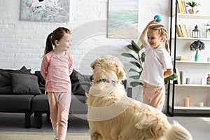 cute little children playing with golden retriever dog