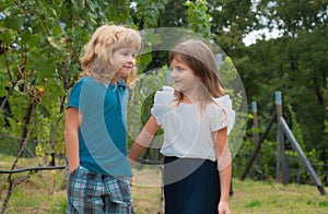 Cute little children playing outdoors. Portrait of two happy young kids at the spring park. Cute lovely boy and girl in