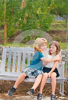 Cute little children playing outdoors. Portrait of two happy young kids at the summer park. Brother hugging her sister.