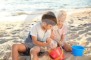 Cute little children playing with sand on sea beach