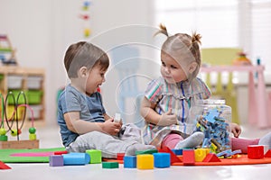 Cute little children playing together on floor