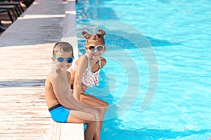 Cute little children sitting near pool