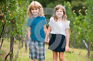 Cute little children walking outdoors. Portrait of two happy young kids at the spring park. Cute lovely boy and girl in