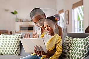 Cute little daughter and african mother using digital tablet to do a video call