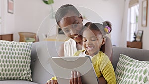 Cute little daughter and african mother using digital tablet to do a video call