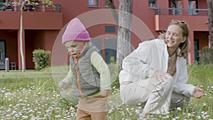 Cute little daughter running across field with flowers