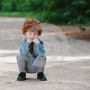 Cute little emotional boy outdoors