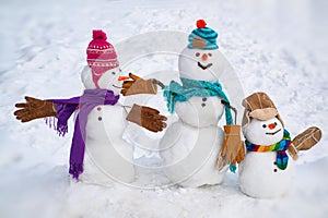 Cute little family snowman outdoor. Happy family of Snowman on a background snow-covered fir branches. Happy smiling