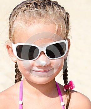 Cute little girl anoints her nose protective cream