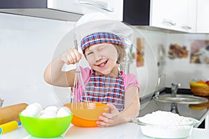 Cute little girl in apron cooking cookies