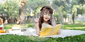 Cute little girl asian read book in park