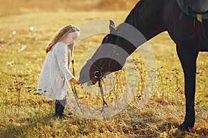 Cute little girl in a autumn field with horse