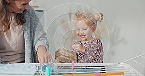 Cute little girl in the bathroom. Clean washed clothes on drying rack. Mother's helper, sweet child helps with