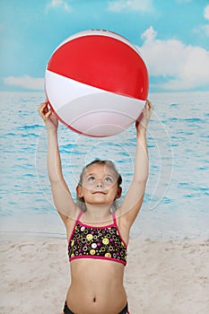 Cute little girl on beach with ball