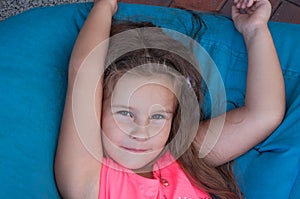 Cute little girl on bean bags, resting, portrait, long hair