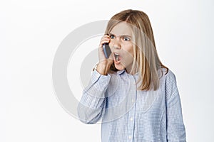 Cute little girl, beautiful blond kid talking on mobile phone, having conversation on smartphone, answer a call