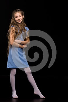 Cute little girl in a beautiful dress on a black background.