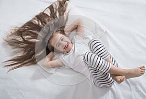 Cute little girl in bed woke up in the morning