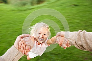 Cute little girl being spun in circles at park photo