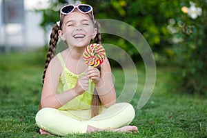 Cute little girl with big colorful lollipop.