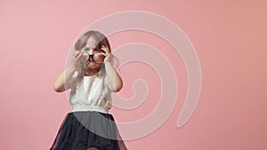 Cute little girl in big glasses for vision. Beautiful bright festive outfit.