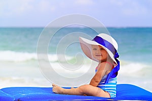 Cute little girl in big hat on summer beach