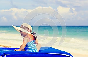 Cute little girl in big hat on summer beach