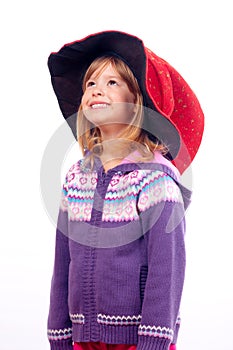 Cute little girl with big red wizards hat smiling