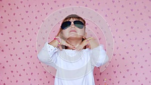 Cute little girl with big sunglasses, making faces and having fun; children and positive emotions