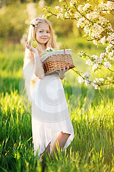 Cute little girl in blossom apple tree garden