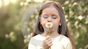 Cute little girl blow on a dandelion. Rest at nature