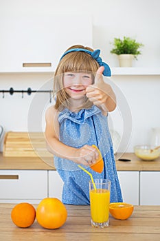 Cute little girl in blue dress press an orange and show Like