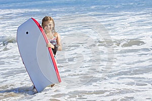 Cute little girl boarding in the ocean