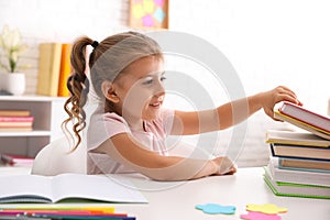 Cute little girl with books doing homework