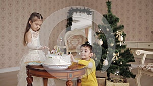 Cute little girl and boy lay sweet snowflakes on a Christmas cake. beautiful children in a spacious and bright room near