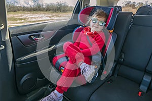 Cute little girl in car safety seat. Baby security during driving