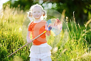 Cute little girl catching butterflies and bugs with her scoop-net