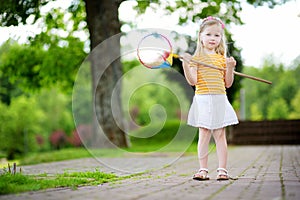 Cute little girl catching butterflies with a scoop-net