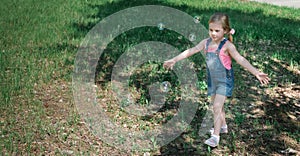 Cute little girl catching soap bubbles