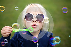 Cute Little Girl Child Blowing Bubbles Outside on a Summer Day