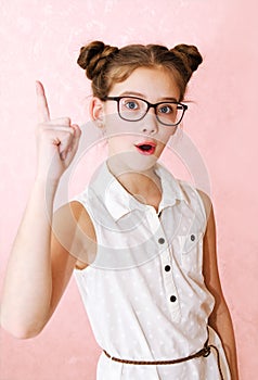 Cute little girl child preteen in eyeglasses with finger up education, school and vision concept isolated