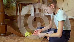 Cute little girl cleaning floor and finding gold necklace