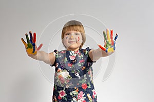 Cute little girl with colorful painted hands on isolated white background