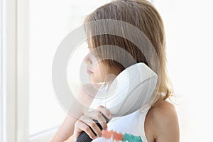 Cute little girl combing her hair with comb