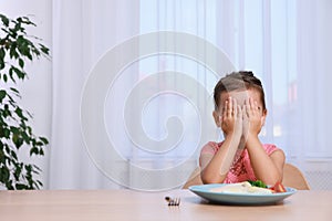 Cute little girl crying and refusing to eat her breakfast at home, space for text