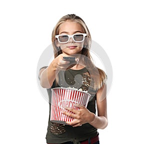 Cute little girl with cup of popcorn switching channels on white background