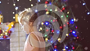 Cute little girl dancing, background decorated Christmas tree